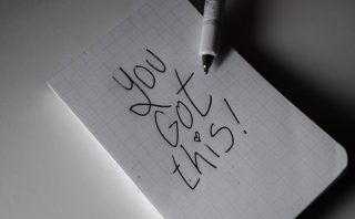 Inspirational handwritten note on graph paper with pen. Encouraging words 'You got this!'